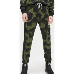 Joggery z nadrukiem - Khaki. Brązowe spodnie męskie Cropp, s, z nadrukiem. Za 99,99 zł.