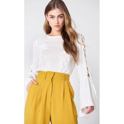 NA-KD Boho Haftowana bluzka z wiązanym rękawem - White. Białe bluzki damskie marki NA-KD Boho, z haftami, z tkaniny, boho, bez kołnierzyka, bez rękawów. W wyprzedaży za 40,47 zł.