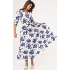 Biało-Niebieska Sukienka Joyous. Niebieskie sukienki damskie Born2be, s, w kwiaty, bez kołnierzyka, bez rękawów, maxi, kopertowe. Za 89,99 zł.