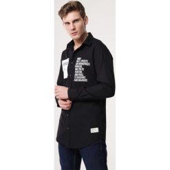 Czarna Koszula Heartwarming. Czarne koszule męskie Born2be, xl, z napisami, z kontrastowym kołnierzykiem, bez rękawów. Za 49,99 zł.