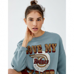 Bluza z efektem sprania i napisem. Niebieskie bluzy damskie marki Pull&Bear, z napisami, bez rękawów, bez kaptura. Za 99,90 zł.