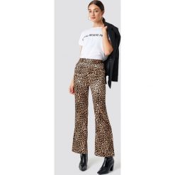 NA-KD Trend Spodnie Flared Shiny Leo - Brown. Brązowe spodnie damskie marki NA-KD Trend, z materiału, z podwyższonym stanem. Za 141,95 zł.