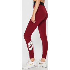 Nike Sportswear - Legginsy. Czerwone spodnie damskie Nike Sportswear, s, z nadrukiem, z elastanu. W wyprzedaży za 119,90 zł.