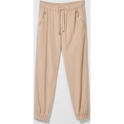 Spodnie jogger fit z lyocellu -. Spodnie damskie Mohito, bez wzorów, z lyocellu. W wyprzedaży za 59,99 zł.