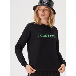 Bluza z neonowym napisem - Czarny. Bluzy damskie Sinsay. Za 39,99 zł.
