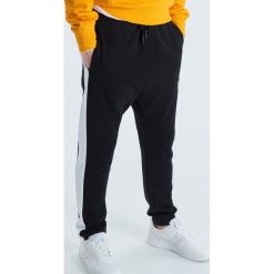 Dresowe joggery z lampasem - Czarny. Czarne spodnie męskie marki Cropp, s, bez wzorów, z dresówki. Za 99,99 zł.