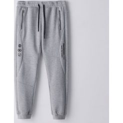 Dresowe joggery z nadrukiem - Jasny szary. Szare spodnie męskie Cropp, s, z nadrukiem, z dresówki. Za 109,99 zł.