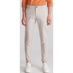 Bawełniane spodnie slim fit - Beżowy. Brązowe spodnie męskie Reserved, m, bez wzorów, z bawełny. Za 129,99 zł.