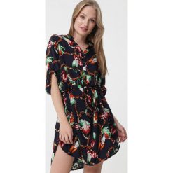 Granatowa szmizjerka mini z abstrakcyjnym wzorem. Niebieskie sukienki damskie Born2be, xl, w paski, ze stójką, bez rękawów, mini, szmizjerki. Za 59,99 zł.