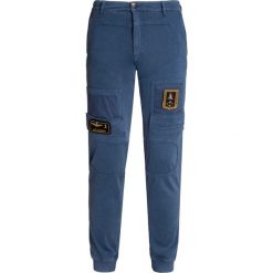 Spodnie AERONAUTICA MILITARE Niebieski. Niebieskie spodnie męskie marki Aeronautica Militare, z aplikacjami, z tkaniny, militarne. Za 1000,00 zł.