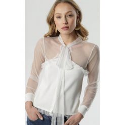 Biała Bluzka Clodagh. Białe bluzki damskie Born2be, s, bez wzorów, z dzianiny, z falbankami, z długim rękawem. Za 99,99 zł.