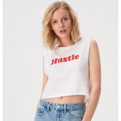 Krótki tank top z napisem retro - Biały. Białe topy damskie Sinsay, s, z napisami, bez kołnierzyka. W wyprzedaży za 9,99 zł.