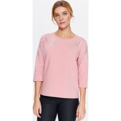 BLUZA NIEROZPINANA DAMSKA Z BŁYSZCZĄCYM NADRUKIEM. Różowe bluzy sportowe damskie Top Secret, na lato, z nadrukiem, z dzianiny, bez rękawów, bez kaptura. W wyprzedaży za 29,99 zł.