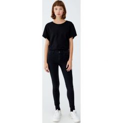 Jeansy super skinny ze średnim stanem. Czarne rurki damskie Pull&Bear, z jeansu. Za 79,90 zł.