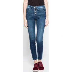 Guess Jeans - Jeansy 1981. Niebieskie jeansy damskie Guess Jeans, z aplikacjami, z elastanu, z podwyższonym stanem. W wyprzedaży za 269,90 zł.