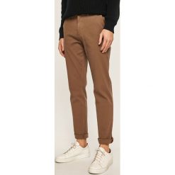 Tommy Hilfiger - Spodnie. Pomarańczowe spodnie męskie TOMMY HILFIGER, na co dzień, bez wzorów, z elastanu. Za 449,90 zł.