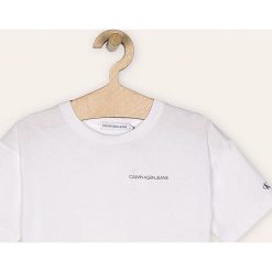 Calvin Klein Jeans - T-shirt dziecięcy 116-176 cm. Białe bluzki dziewczęce Calvin Klein Jeans, z nadrukiem, z bawełny, z okrągłym kołnierzem, z krótkim rękawem, krótkie, bez kaptura. Za 119,90 zł.