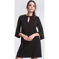 Czarna Sukienka Serious. Czarne sukienki damskie marki other, na imprezę, s, bez wzorów, z falbankami, bez rękawów, mini. Za 79,99 zł.