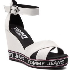 Sandały TOMMY JEANS - Pop Webbing Wedge Sandal EN0EN00448 White 100. Białe klapki damskie marki Tommy Jeans, bez wzorów, z jeansu, bez obcasa, na obcasie. Za 399,00 zł.