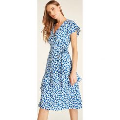 Sukienka w kolorze niebiesko-białym. Niebieskie sukienki damskie Heine, bez wzorów, bez kołnierzyka, bez rękawów, midi, kopertowe. W wyprzedaży za 175,95 zł.