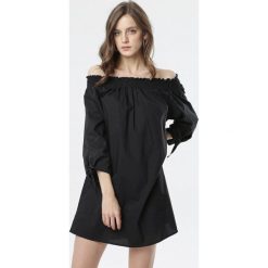 Czarna Sukienka Morea. Czarne sukienki damskie Born2be, s, bez wzorów, z jeansu, bez kołnierzyka, bez rękawów, mini, oversize. Za 89,99 zł.