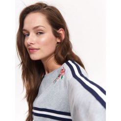 BLUZA NIEROZPINANA DAMSKA Z HAFTEM, Z TAŚMAMI. Szare bluzy damskie TROLL, na lato, xs, z haftami, z dzianiny, bez rękawów, bez kaptura. W wyprzedaży za 69,99 zł.