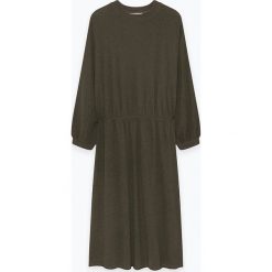 Sukienka "Binistate" w kolorze khaki. Brązowe sukienki damskie American Vintage, bez wzorów, z okrągłym kołnierzem, bez rękawów, maxi, rozkloszowane. W wyprzedaży za 249,95 zł.