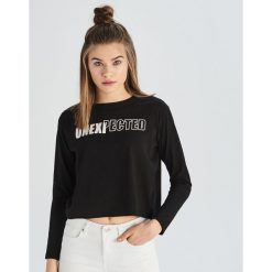 Bawełniany crop top z nadrukiem - Czarny. Czarne topy damskie Sinsay, s, z nadrukiem, z bawełny, bez kołnierzyka. W wyprzedaży za 14,99 zł.
