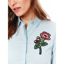 Klasyczna koszula z kwiatowym haftem. Niebieskie koszule damskie na lato, z haftami, z bawełny, eleganckie. W wyprzedaży za 34,99 zł.