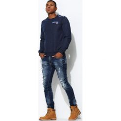 Niebieskie Jeansy Stronger. Czarne jeansy męskie marki Born2be, m, z nadrukiem, z dresówki, z kapturem. Za 54,99 zł.