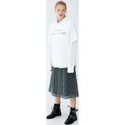 Biała koszulka z kolorowym napisem. Białe t-shirty damskie marki Pull&Bear, w kolorowe wzory. Za 59,90 zł.