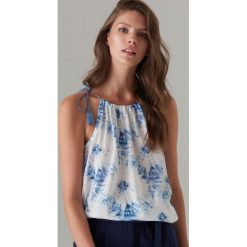 Top z motywem tie dye - Niebieski. Niebieskie topy damskie Mohito, s, bez wzorów, bez kołnierzyka. W wyprzedaży za 19,99 zł.
