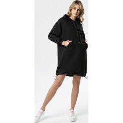 Czarna Sukienka Cally. Czarne sukienki damskie Born2be, s, bez wzorów, z dzianiny, z kapturem, z długim rękawem, długie, midi, oversize. Za 129,99 zł.