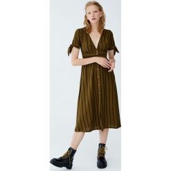 Sukienka midi w paski z węzłem. Czarne sukienki damskie z falbanami marki Pull&Bear, w paski, midi. Za 99,90 zł.