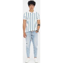 Jeansy z efektem zużycia i dziurami. Niebieskie jeansy męskie z dziurami marki Pull&Bear. Za 139,00 zł.