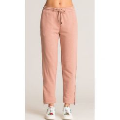 Różowe spodnie dresowe Emporio Armani z ozdobnymi zamkami. Różowe spodnie damskie Emporio Armani, z dresówki. Za 419,50 zł.