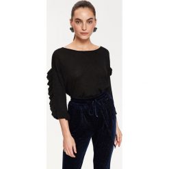 Sweter z metalizowaną nicią i falbaną na rękawie. Czarne swetry damskie Top Secret, na lato, bez wzorów, z dzianiny, eleganckie, bez rękawów, bez kaptura. W wyprzedaży za 69,99 zł.