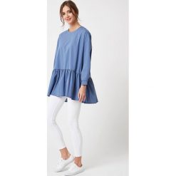Bluzka z falbanką na dole niebieska. Niebieskie bluzki damskie e-margeritka.pl, s, bez wzorów, z bawełny, eleganckie, z długim rękawem, długie, bez kaptura. Za 148,99 zł.