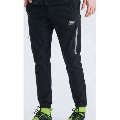 Spodnie joggery z kolekcji Nasa - Czarny. Czarne joggery męskie marki Cropp, m. Za 129,99 zł.