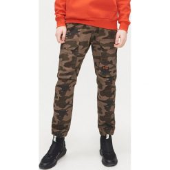Joggery z kieszeniami cargo - Khaki. Brązowe spodnie męskie Cropp, m. Za 149,99 zł.