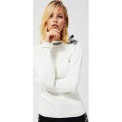 Sweter z ozdobną kokardą w kratę. Brązowe swetry damskie Moodo, xs, w kratkę, z wiskozy, z długim rękawem, długie, bez kaptura. Za 49,99 zł.
