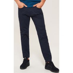 Materiałowe spodnie slim fit - Granatowy. Niebieskie rurki męskie marki House, z materiału. Za 89,99 zł.