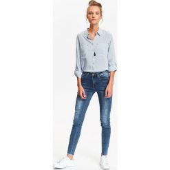 SPODNIE DŁUGIE DAMSKIE, OBCISŁE JEANSY Z NIEWYKOŃCZONĄ NOGAWKĄ. Szare jeansy damskie skinny marki Top Secret. Za 49,99 zł.