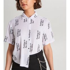Koszula oversize z napisami - Biały. Białe koszule damskie Cropp, xs, z napisami, bez kołnierzyka, bez rękawów. W wyprzedaży za 29,99 zł.