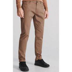 Bawełniane spodnie slim - Beżowy. Brązowe spodnie męskie Reserved, m, bez wzorów, z bawełny. Za 129,99 zł.