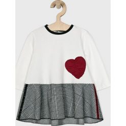 Blukids - Sukienka dziecięca 74-98 cm. Białe sukienki dziewczęce Blukids, bez wzorów, z bawełny, casualowe, bez rękawów, mini, rozkloszowane. W wyprzedaży za 69,90 zł.