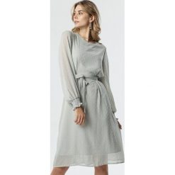 Jasnoszara Sukienka Aguirre. Szare sukienki damskie Born2be, na imprezę, s, bez wzorów, z tkaniny, eleganckie, z okrągłym kołnierzem, z długim rękawem, długie, midi, trapezowe. Za 119,99 zł.