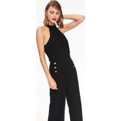 MODNY KOMBINEZON DAMSKI Z DEKOLTEM HALTER ZDOBIONY ZŁOTYMI GUZIKAMI. Czarne kombinezony eleganckie marki Top Secret, na zimę, z dekoltem halter, z długim rękawem, długie. W wyprzedaży za 59,99 zł.