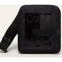 Calvin Klein - Saszetka. Czarne torby męskie skórzane Calvin Klein, w paski, z poliesteru, casualowe, na ramię, małe. Za 269,90 zł.