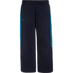 Under Armour Spodnie treningowe midnight navy. Niebieskie spodnie chłopięce marki Under Armour, z materiału. W wyprzedaży za 132,30 zł.